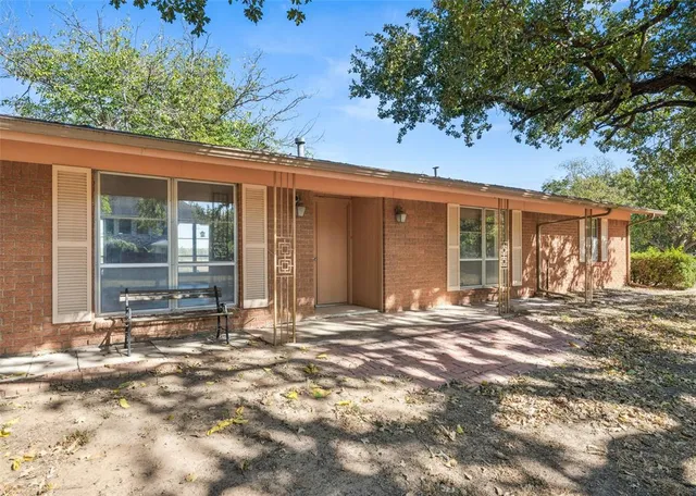 front view of a house with a large window and potted plants