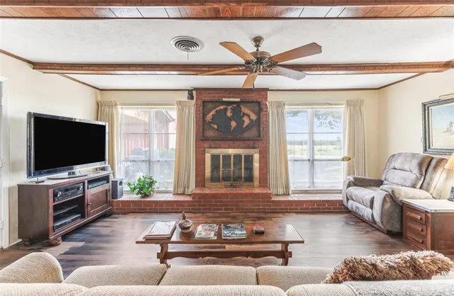 a living room with furniture a flat screen tv and a large window