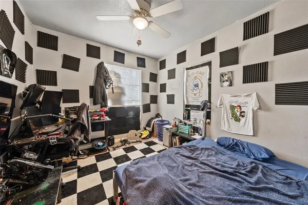 a bedroom with a bed and a black white checkered floor