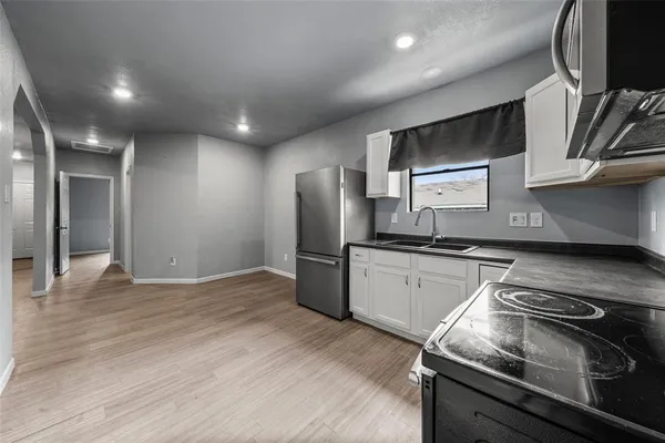 a kitchen with stainless steel appliances granite countertop a refrigerator and a stove top oven