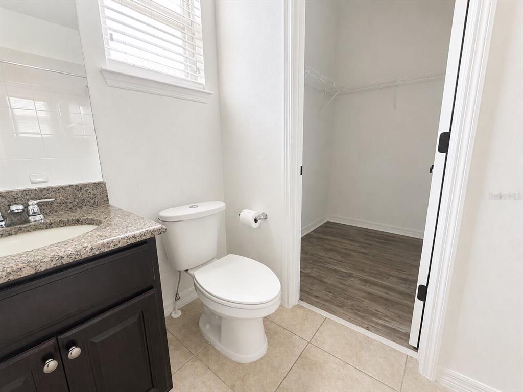 8531 Geddes Loop Orlando, FL 32836 - Photo 13 of 20 a bathroom with a granite countertop toilet and a sink