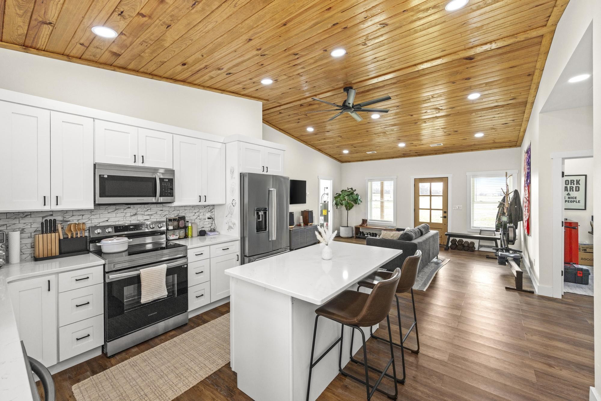 154 North Old Military Road Summertown, TN 38483 - Photo 11 of 45 a kitchen with stainless steel appliances granite countertop a stove a refrigerator a kitchen island a sink dishwasher and white cabinets with wooden floor