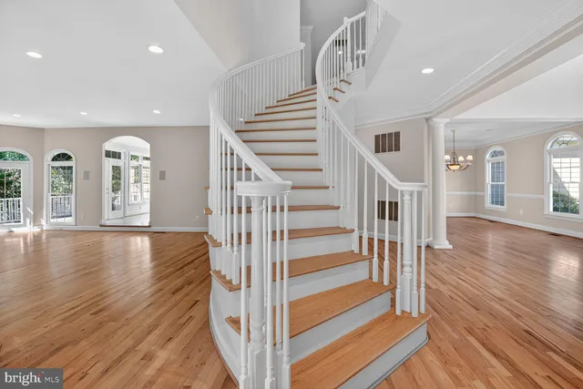 a view of an empty room with wooden floor and windows