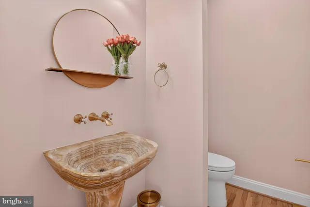 a kitchen with sink a stove and wooden floor