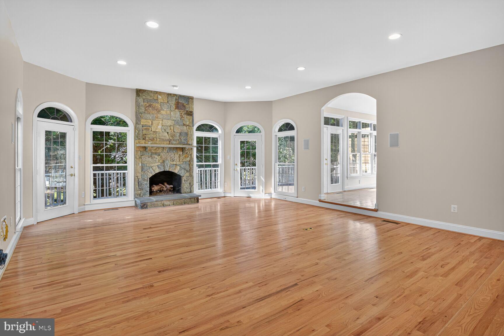 9914 Woodford Road Potomac, MD 20854 - Photo 32 of 87 an empty room with fireplace wooden floor and windows