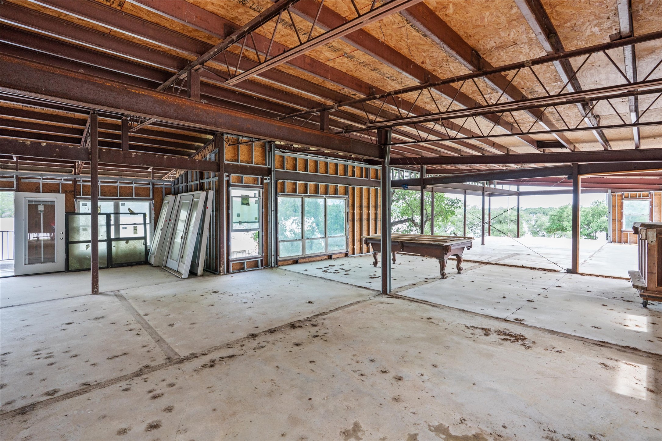 325 Eagle Rest Burnet, TX 78611 - Photo 13 of 40 A spacious, open-concept interior shell with exposed structural beams awaits custom finishes and scenic outdoor views.