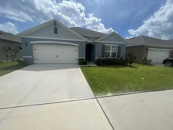 a front view of a house with a garden and plants