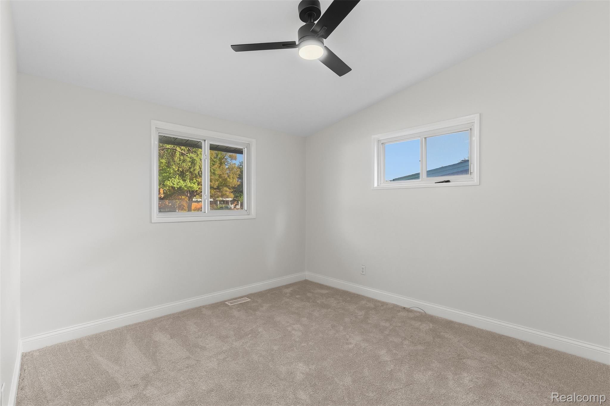 9101 Merriman Road Livonia, MI 48150 - Photo 23 of 41 Neutral tone wall finishes, soft carpet flooring, modern ceiling fan with integrated lighting, and two windows providing natural illumination