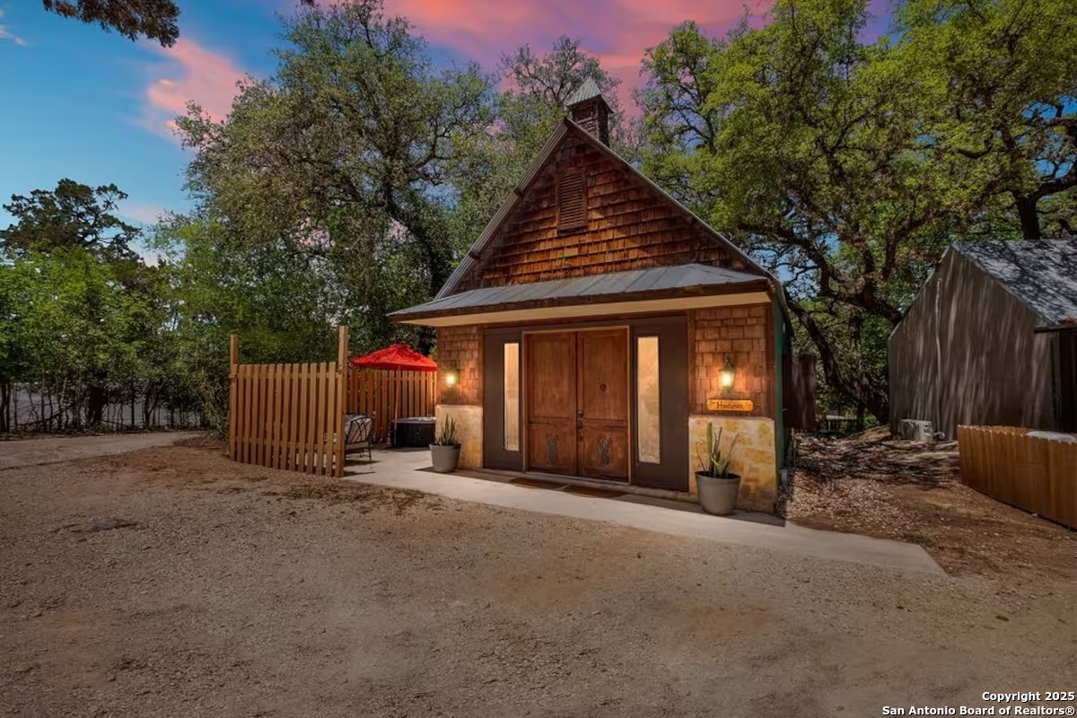 24159 Boerne Stage Road San Antonio, TX 78255 - Photo 2 of 100 a view of a house with floor to ceiling window and wooden fence