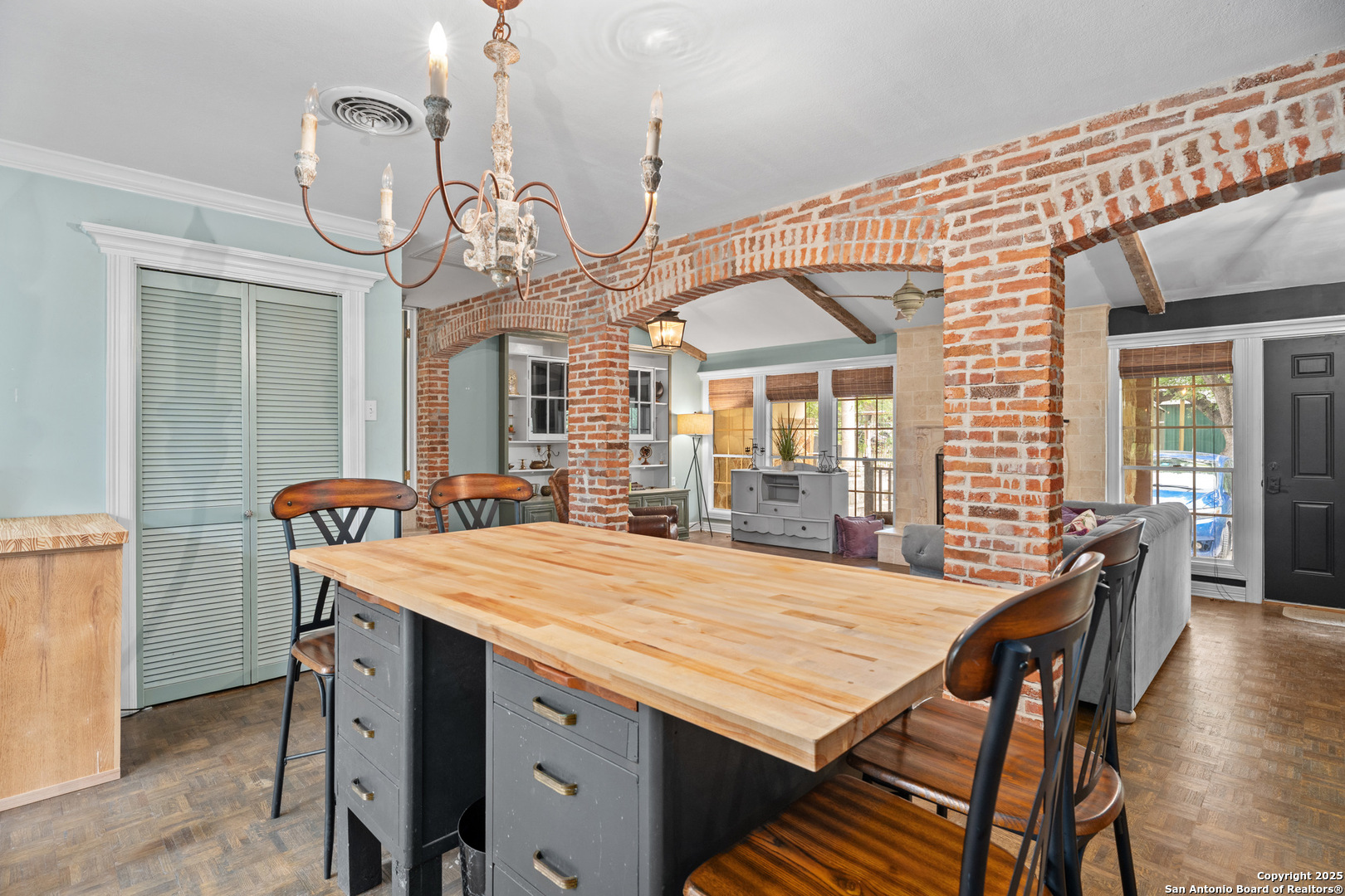 24159 Boerne Stage Road San Antonio, TX 78255 - Photo 65 of 100 a dining room with wooden floor a chandelier a wooden table and chairs