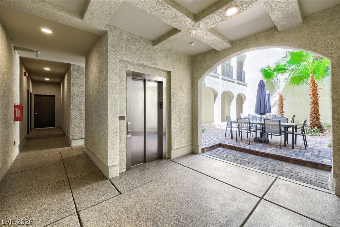 2555 Hampton Road, Unit 9301 Henderson, NV 89052 - Photo 4 of 36 An inviting outdoor patio area with dining space and lush palm trees, perfect for al fresco living.