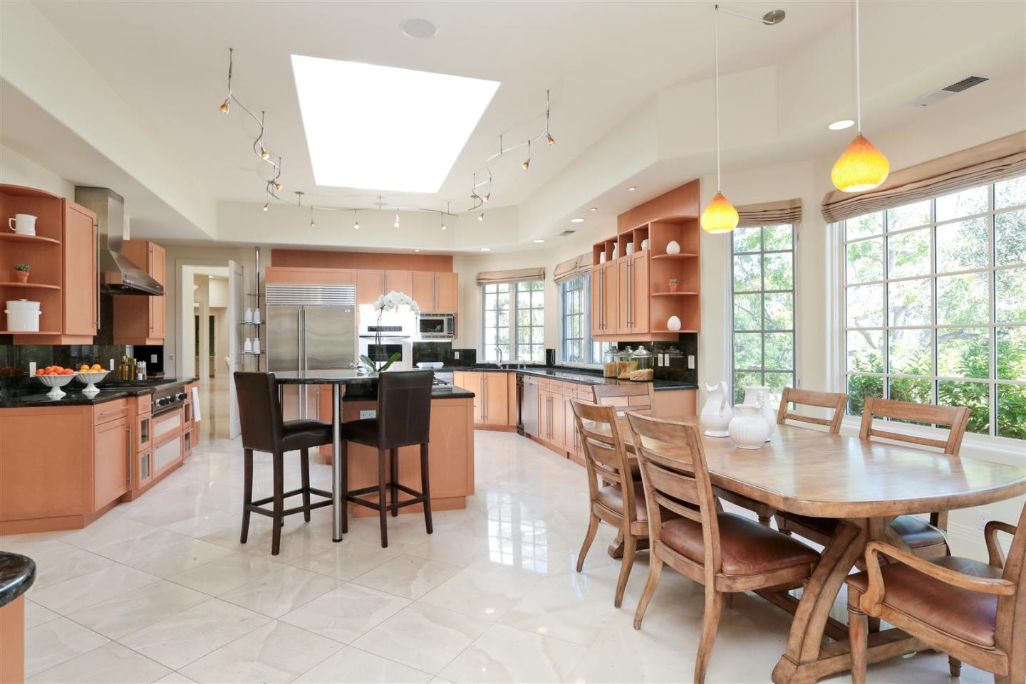24289 Hillview Road Los Altos Hills, CA 94024 - Photo 16 of 32 a kitchen with a dining table chairs and large windows