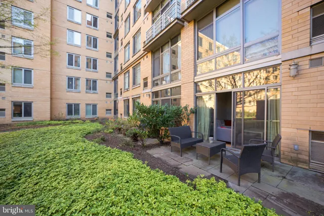 a view of a building with a garden and sitting area