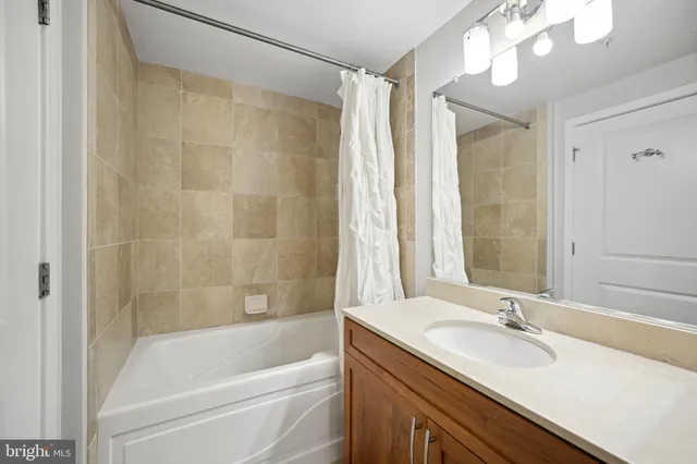 a bathroom with a granite countertop sink and a bathtub