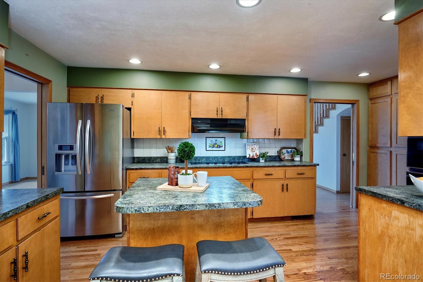 22 Rangeview Drive Wheat Ridge, CO 80215 - Photo 14 of 40 a kitchen with stainless steel appliances granite countertop a refrigerator a stove and a sink
