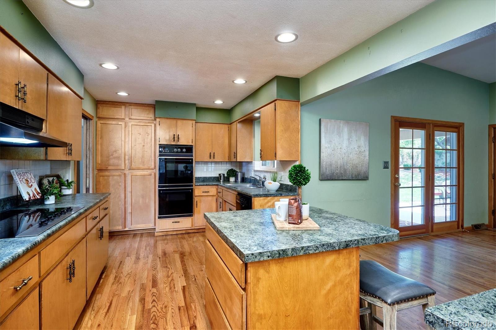 22 Rangeview Drive Wheat Ridge, CO 80215 - Photo 16 of 40 a kitchen with stainless steel appliances granite countertop a sink dishwasher a refrigerator and a stove with wooden floor