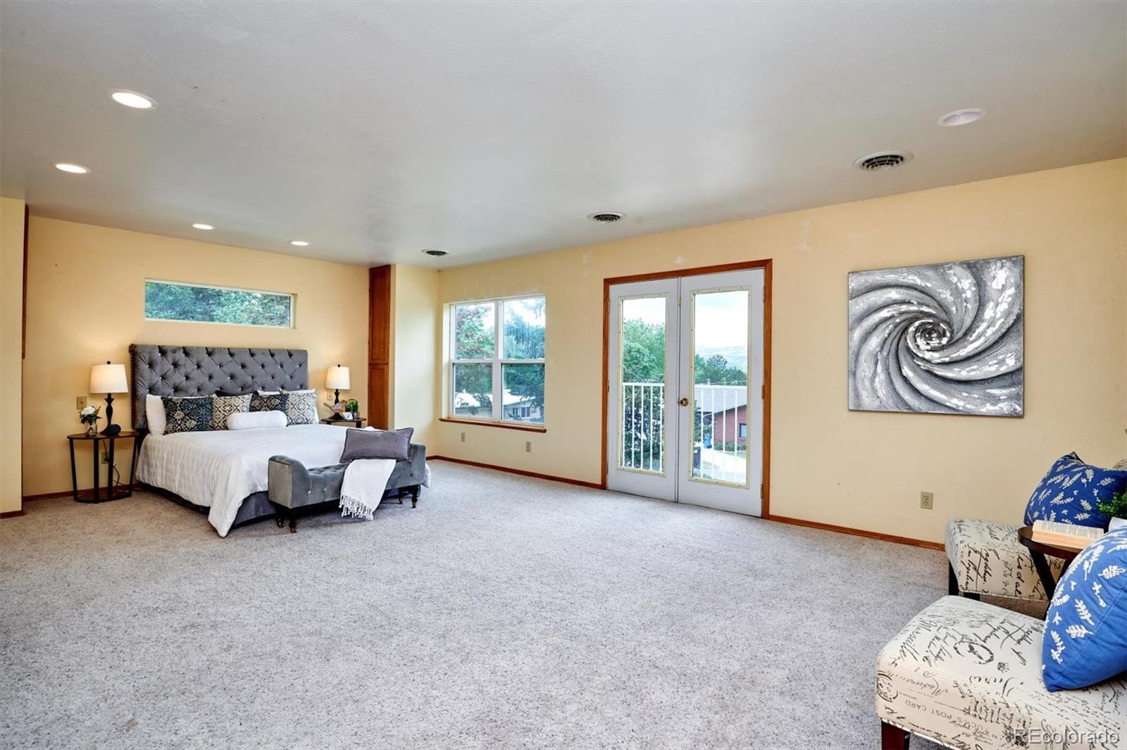 22 Rangeview Drive Wheat Ridge, CO 80215 - Photo 19 of 40 a spacious bedroom with a bed and a couch
