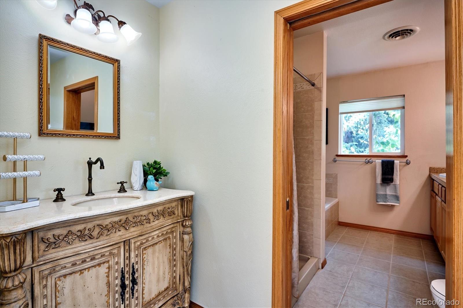 22 Rangeview Drive Wheat Ridge, CO 80215 - Photo 24 of 40 a bathroom with a sink a vanity and a mirror