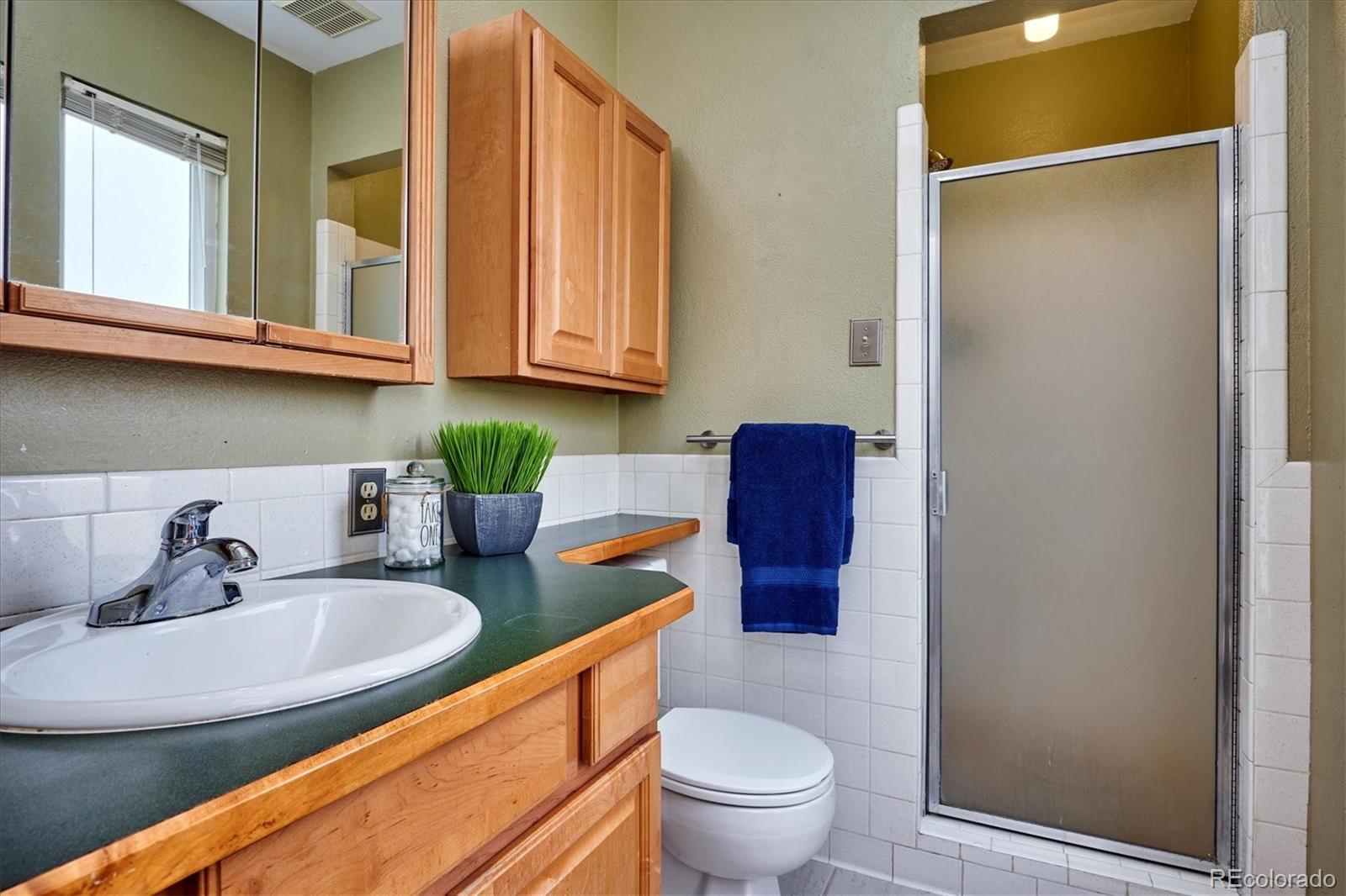 22 Rangeview Drive Wheat Ridge, CO 80215 - Photo 29 of 40 a bathroom with a sink a toilet and a mirror