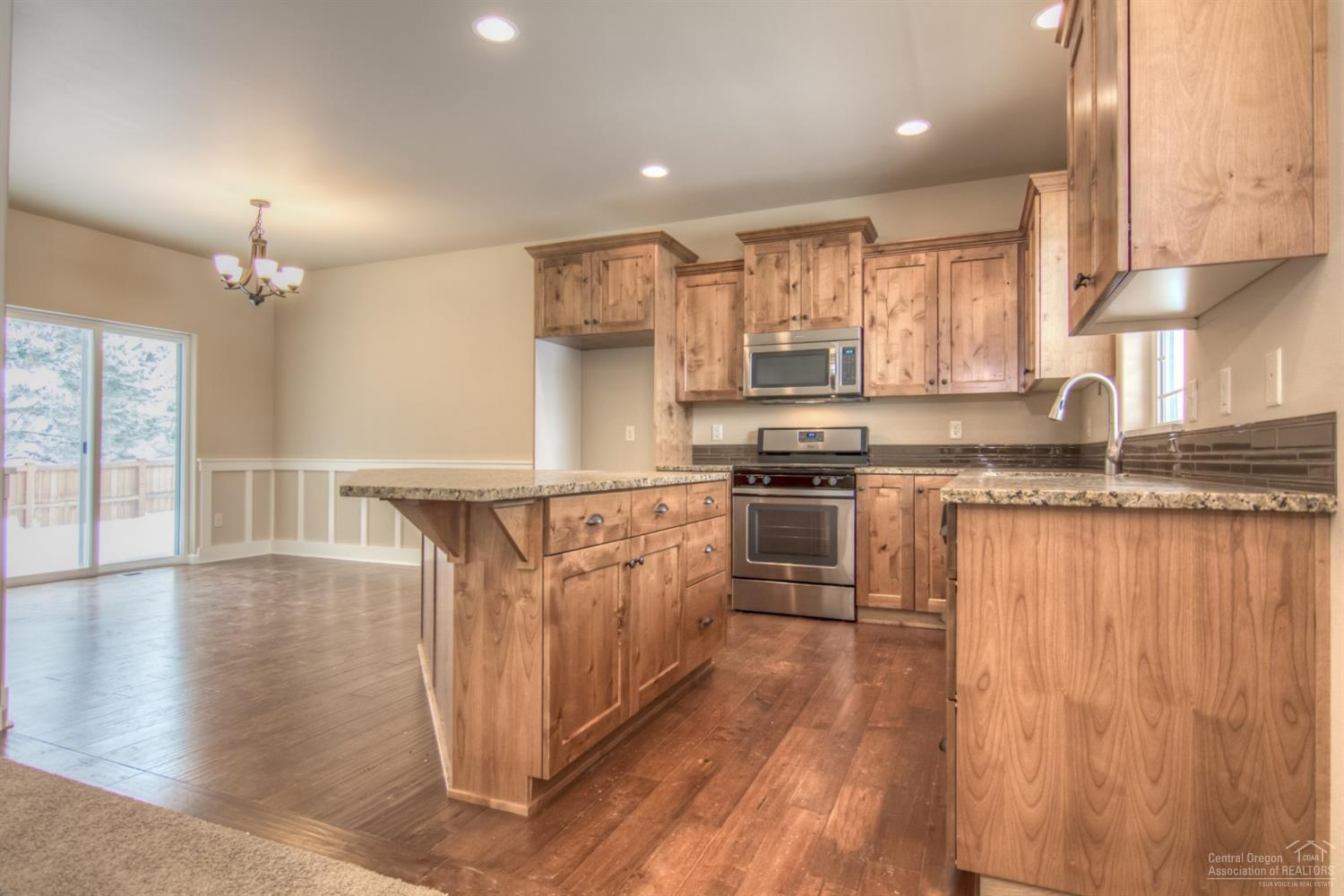 62720 Hawkview Road Bend, OR 97701 - Photo 3 of 16 a kitchen with stainless steel appliances granite countertop a stove a sink and a refrigerator