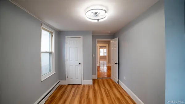 an empty room with a kitchen and wooden floor