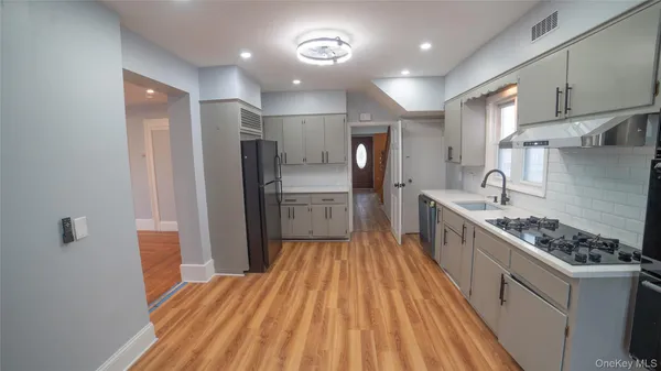 a kitchen with stainless steel appliances a refrigerator and a stove top oven