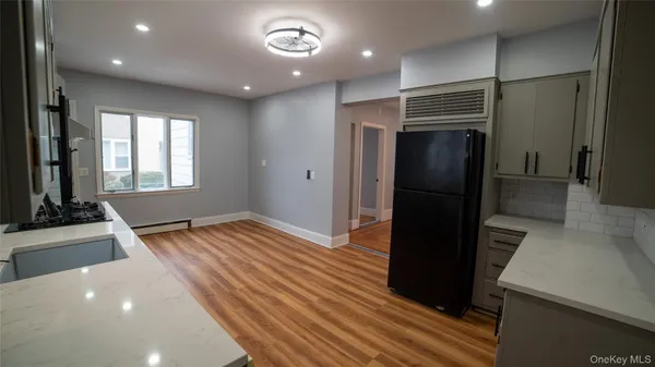 a view of a hallway with wooden floor and a washer dryer