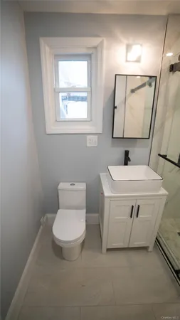a bathroom with a toilet sink and mirror