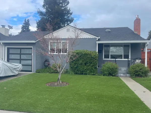 a front view of a house with a garden and plants