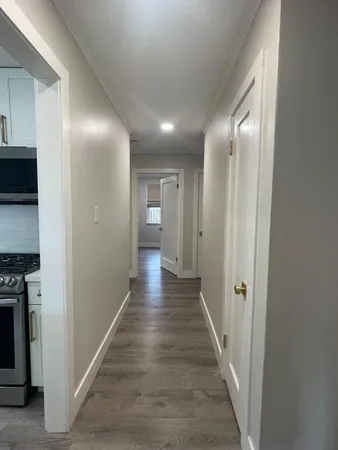 a view of a hallway with wooden floor