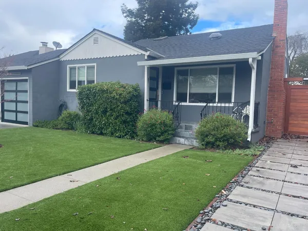 a front view of a house with a garden and yard