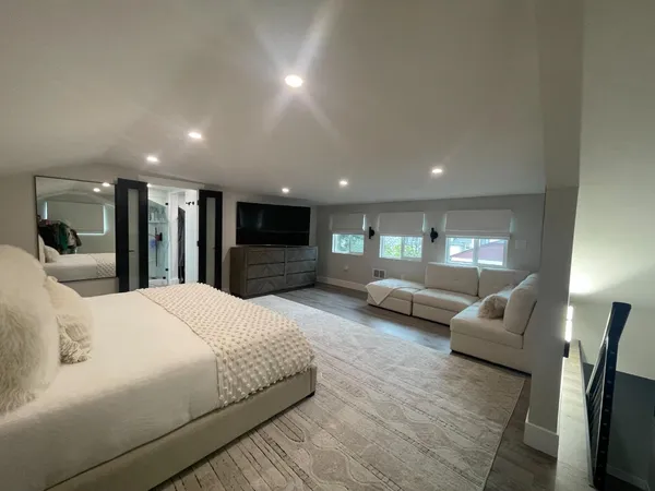 a large bedroom with bed and a large window