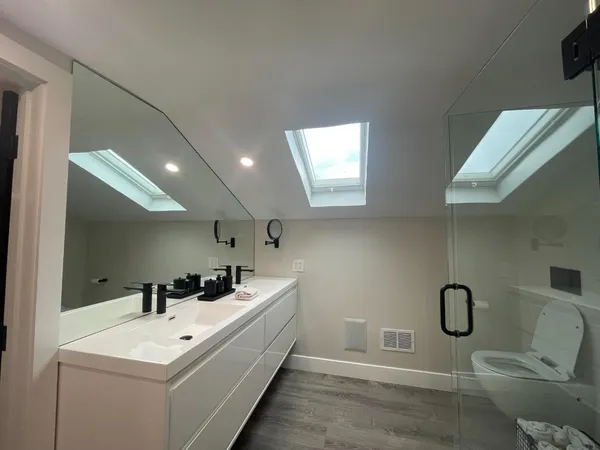 a bathroom with a sink a toilet and mirror