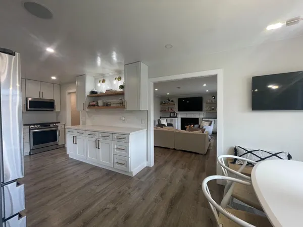 a kitchen with stainless steel appliances granite countertop a sink counter space and wooden floor