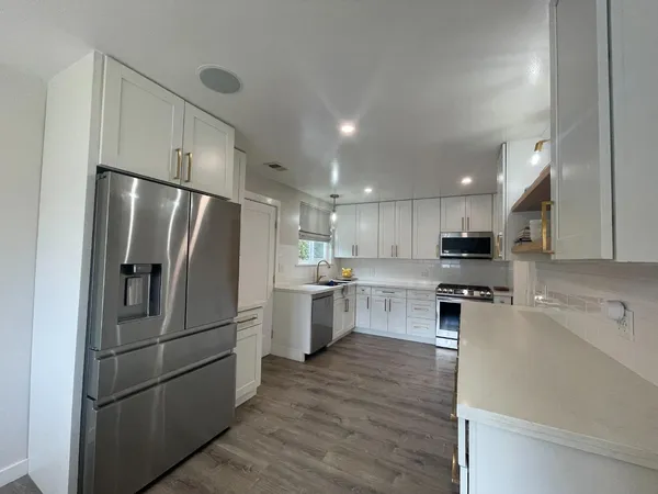 a kitchen with stainless steel appliances a refrigerator sink and stove