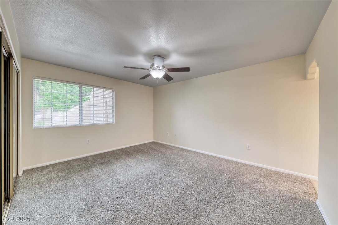 1851 Hillpointe Road, Unit 1811 Henderson, NV 89074 - Photo 19 of 49 Spacious primary bedroom with ceiling fan/light, mirrored closet doors and carpeting.