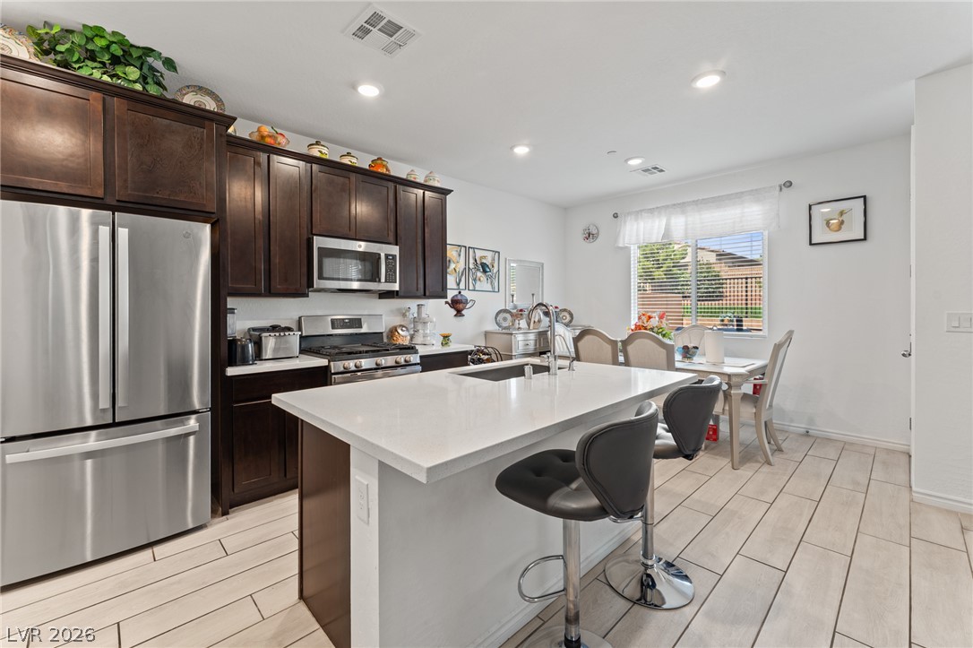 8879 Roadrunner Ravine Street Las Vegas, NV 89166 - Photo 8 of 39 Culinary delights await in this bright kitchen with a spacious island and gleaming stainless-steel appliances.