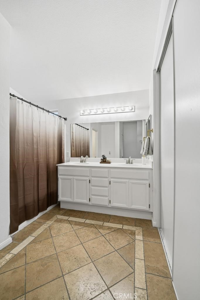 45664 Balmoral Court Lancaster, CA 93534 - Photo 27 of 38 a room with a mirror and a sink