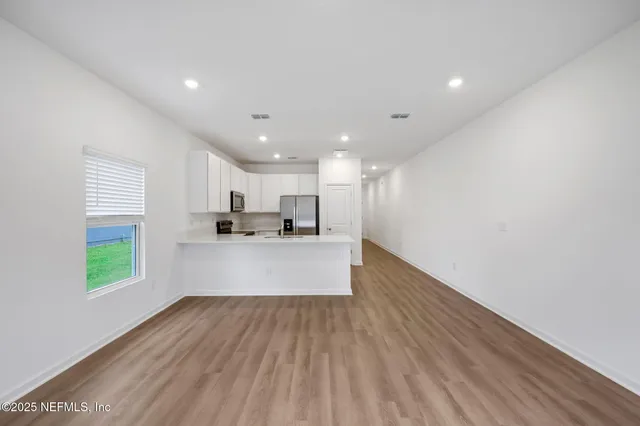 a view of kitchen with kitchen island sink and wooden floor