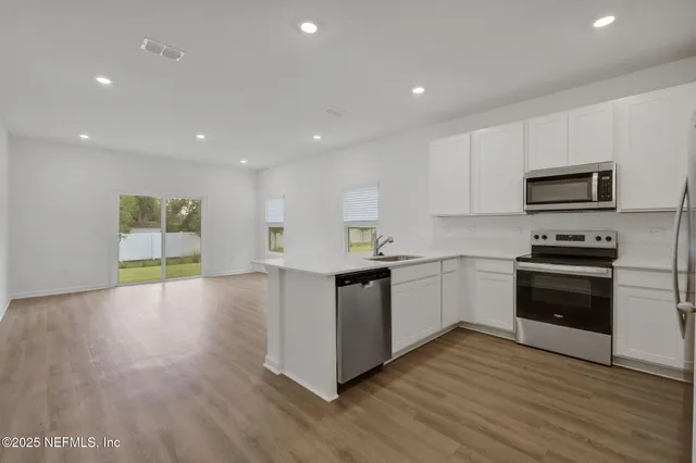 a kitchen with a sink and steel appliances