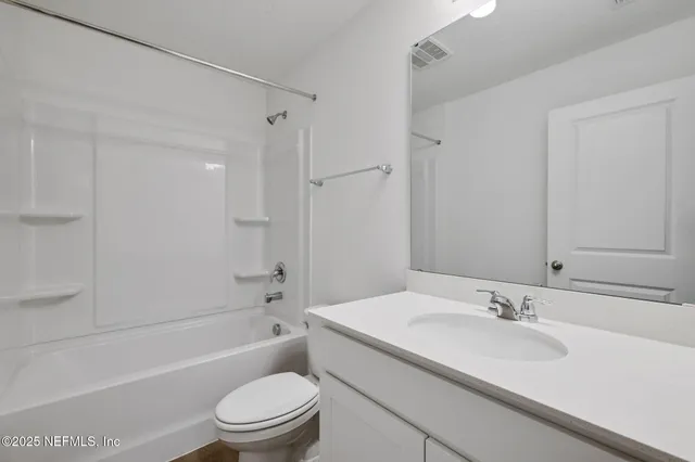 a bathroom with a sink toilet vanity and shower