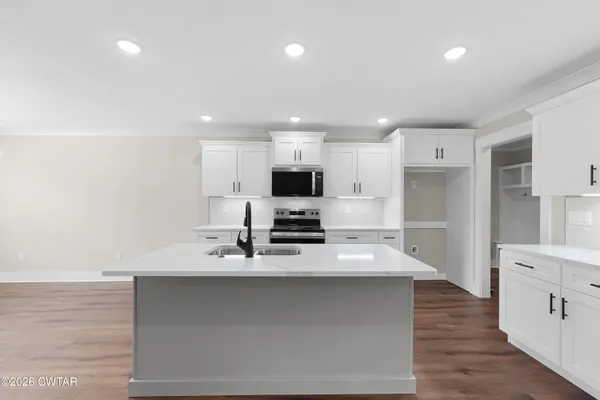 a large kitchen with kitchen island a sink stainless steel appliances and cabinets