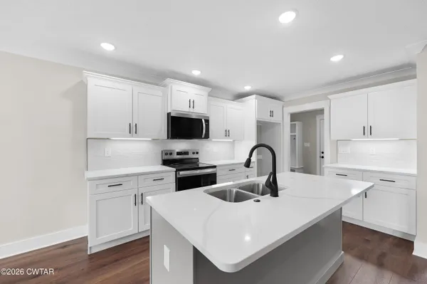 a kitchen with white cabinets stainless steel appliances and sink