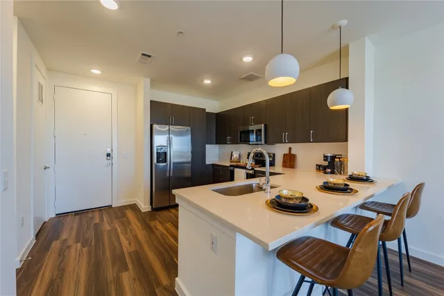 a dining room with granite countertop a table chairs and a chandelier