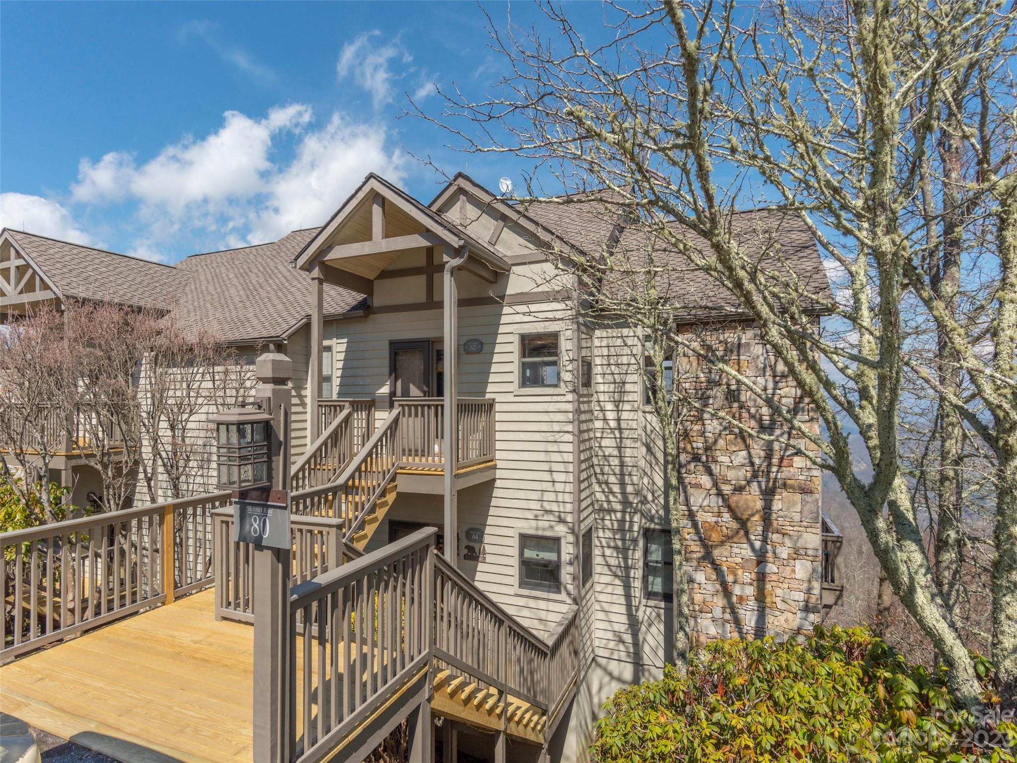 a front view of a house with large trees