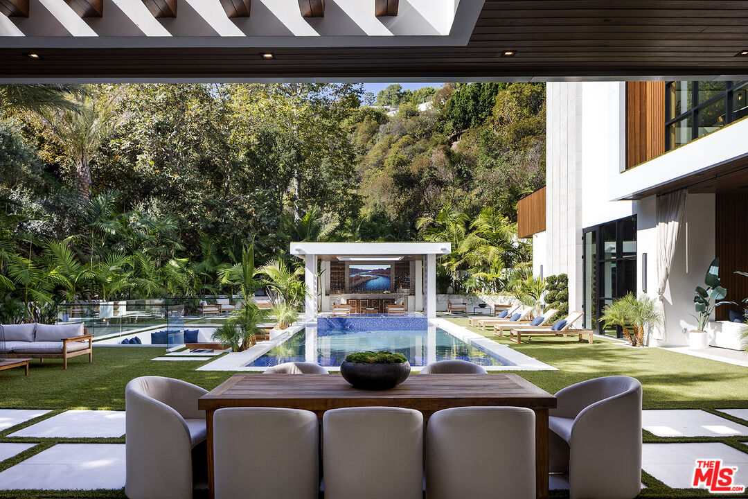 a view of a patio with table and chairs potted plants and large tree