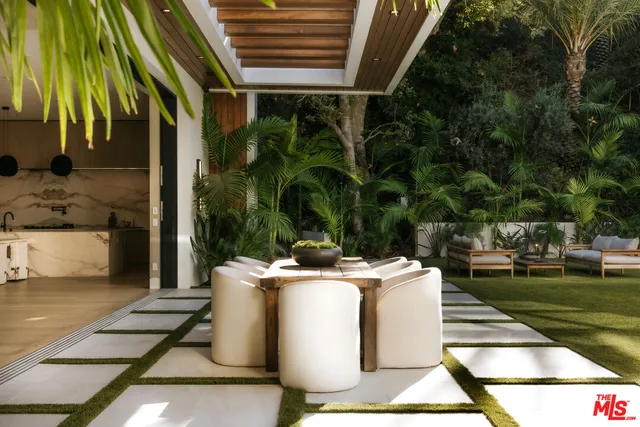 a view of a patio with table and chairs and potted plants