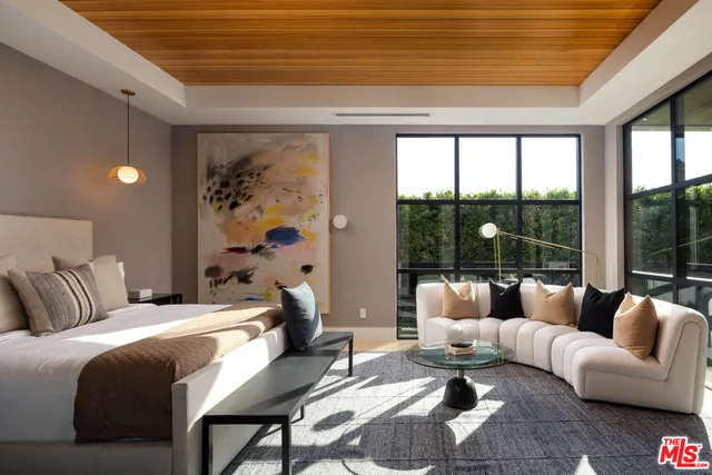 a bedroom with furniture and a large window