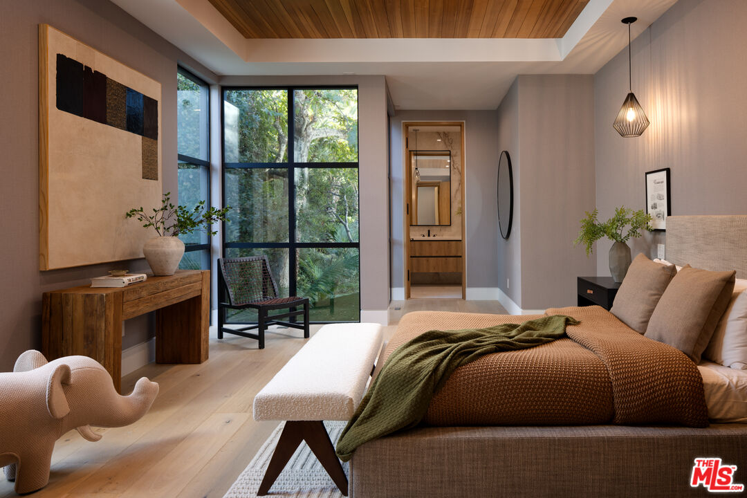 13187 Chalon Road Los Angeles, CA 90049 - Photo 23 of 39 a bedroom with a bed and large windows