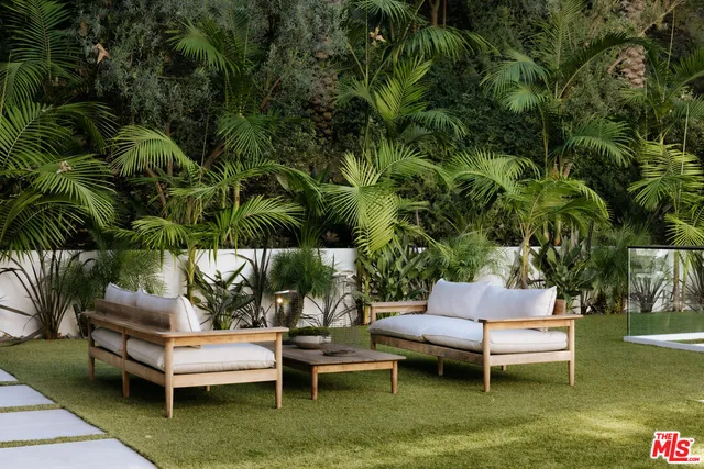 a view of a swimming pool with sitting area and garden